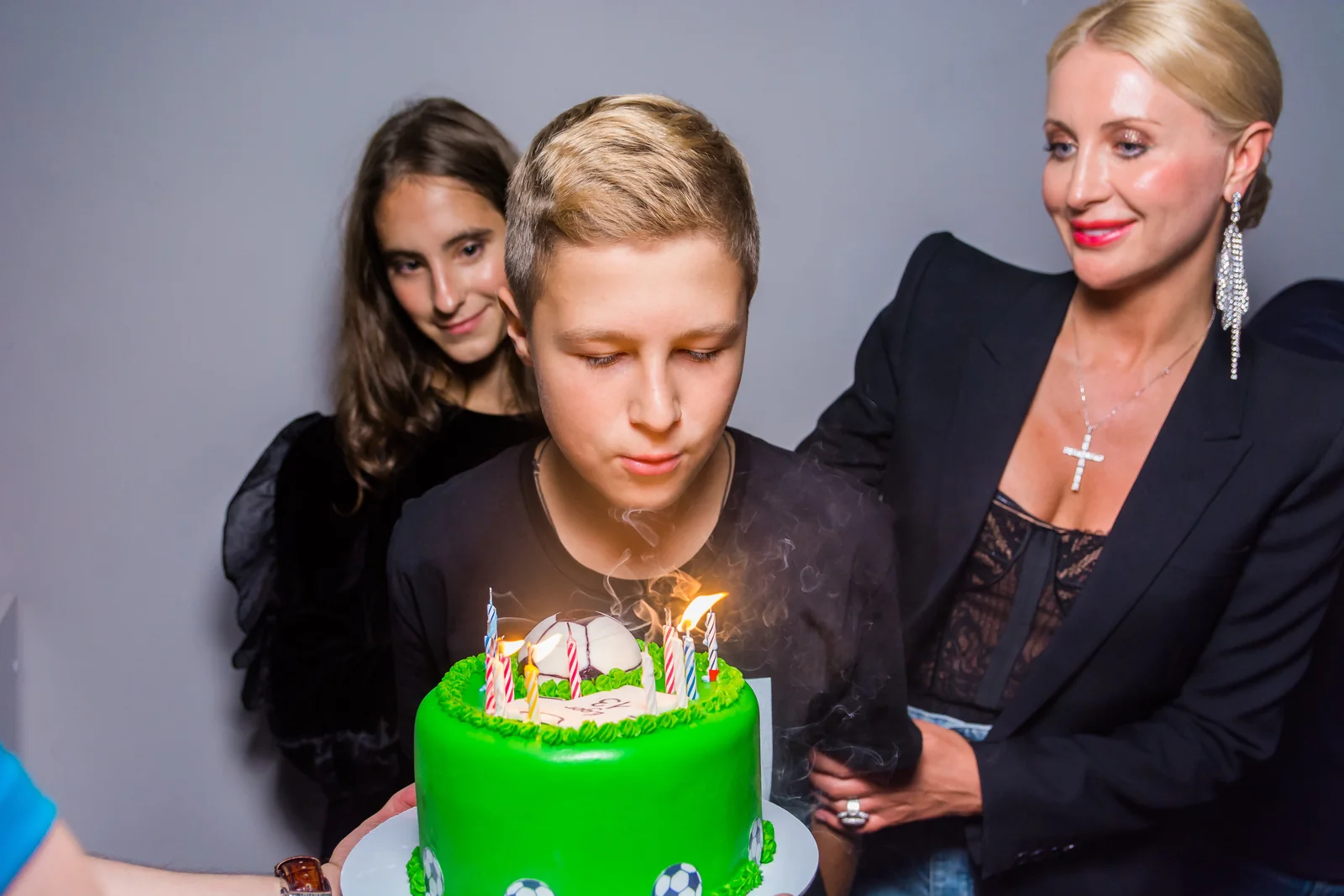 Именинник задувает свечи на торте в LaserLand Чита